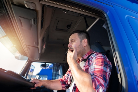trucker yawning at wheel